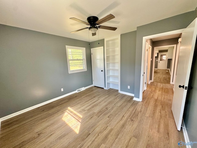 unfurnished bedroom with ceiling fan, light wood-type flooring, and a closet