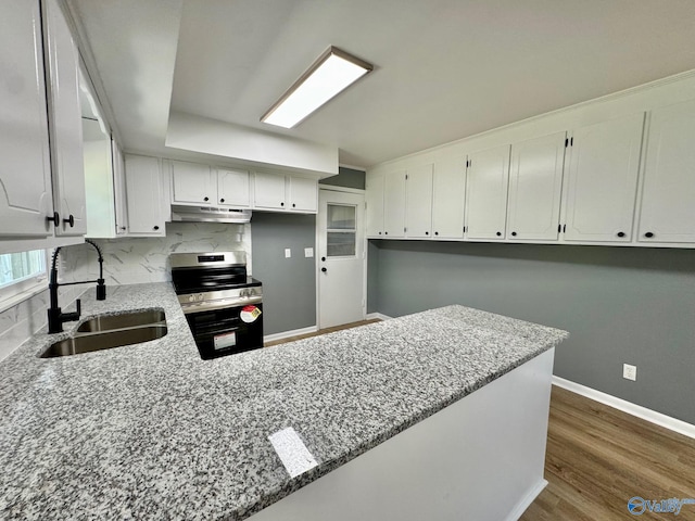 kitchen with sink, kitchen peninsula, white cabinetry, stainless steel range oven, and dark hardwood / wood-style flooring