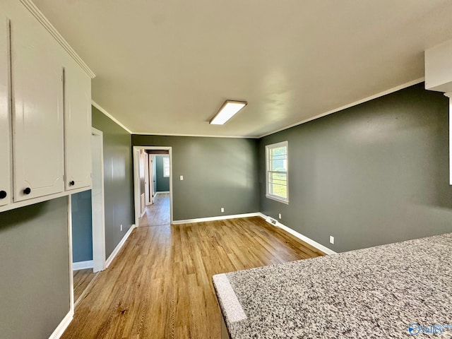 spare room with light hardwood / wood-style floors and crown molding