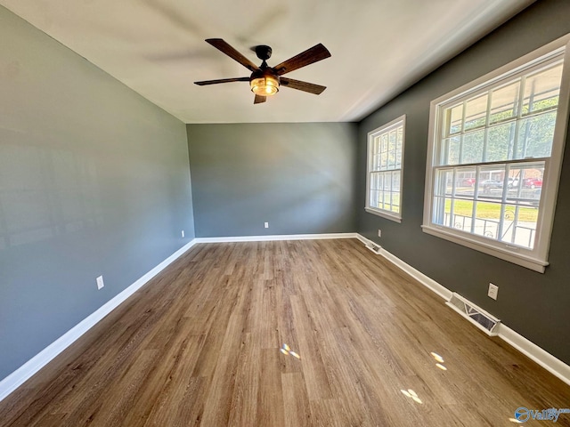 spare room with hardwood / wood-style floors and ceiling fan