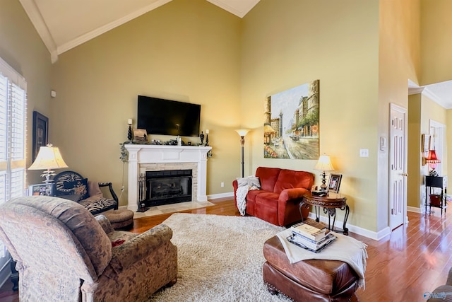 living room featuring baseboards, high vaulted ceiling, wood finished floors, and ornamental molding