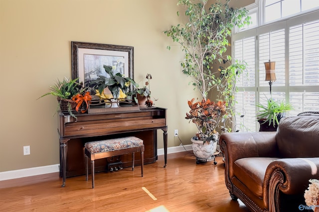 sitting room with baseboards and wood finished floors