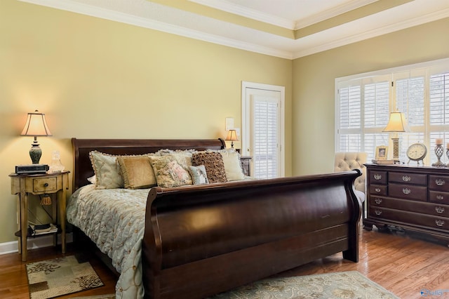 bedroom with crown molding and wood finished floors