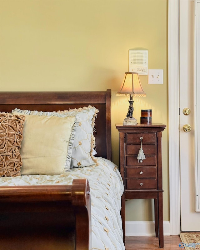 bedroom with baseboards and wood finished floors