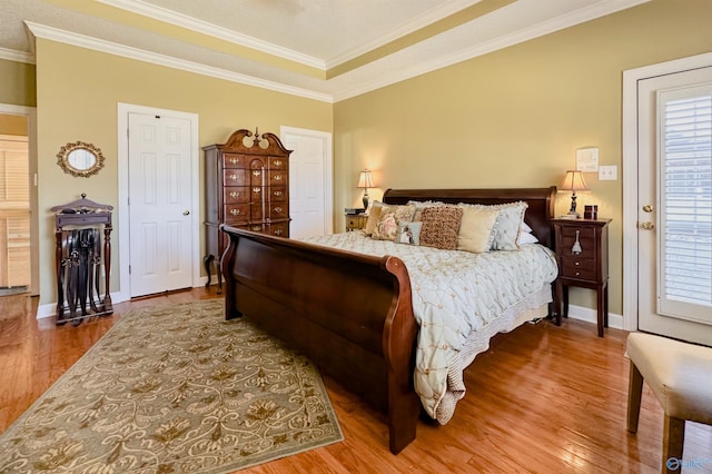 bedroom with crown molding, baseboards, and wood finished floors