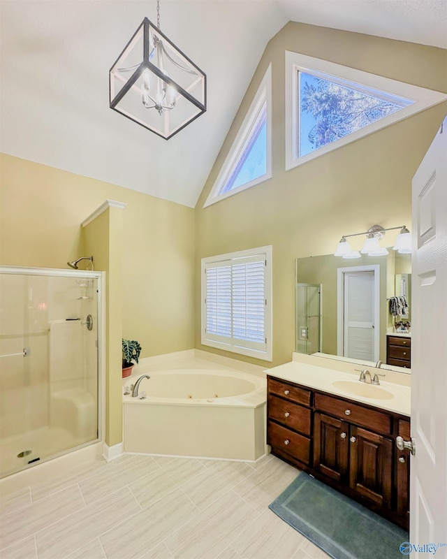 full bath with a chandelier, a tub with jets, vanity, a shower stall, and high vaulted ceiling