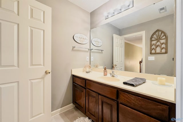 bathroom with visible vents, tile patterned flooring, vanity, and baseboards