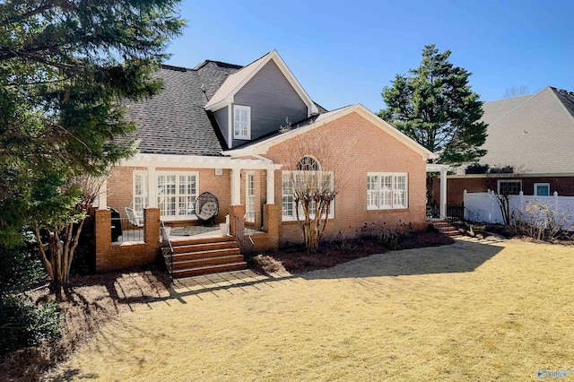 view of front of home with french doors, fence, and brick siding