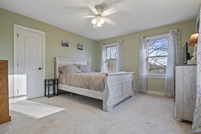 carpeted bedroom featuring ceiling fan and a textured ceiling