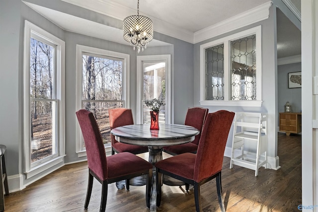 dining space featuring dark wood-type flooring, ornamental molding, and a notable chandelier