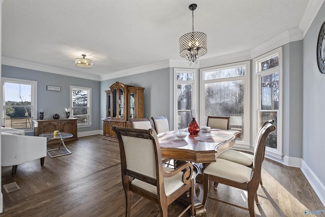 dining room with crown molding, a healthy amount of sunlight, dark wood-type flooring, and an inviting chandelier