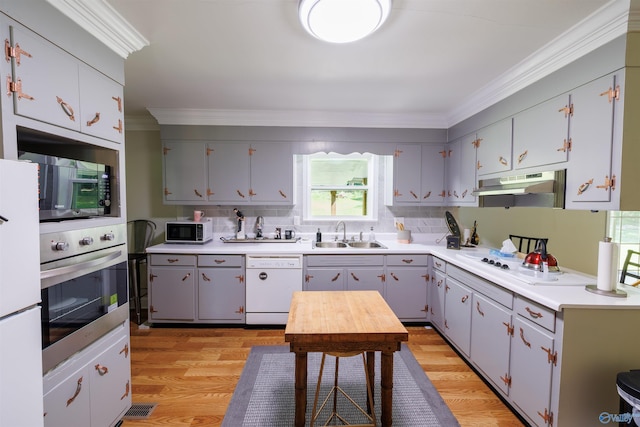 kitchen featuring white appliances, light countertops, a sink, and under cabinet range hood