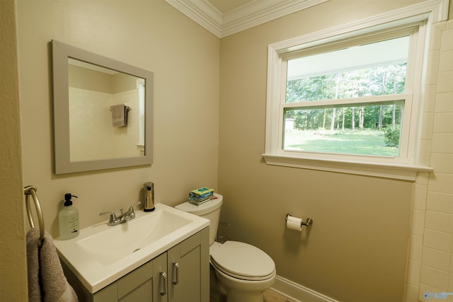 bathroom featuring toilet, baseboards, ornamental molding, and vanity