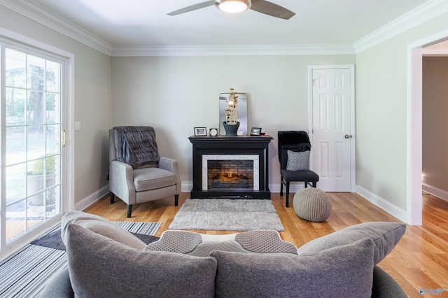 living area with wood finished floors, a fireplace with flush hearth, a ceiling fan, and baseboards
