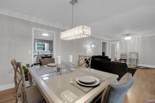 dining area with ornamental molding, baseboards, and wood finished floors