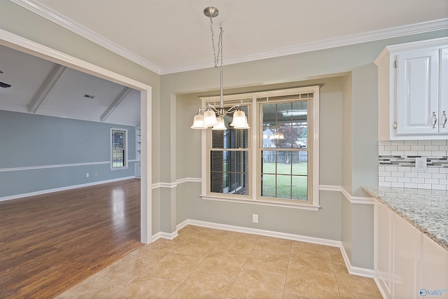 2303 Chatam Ave, Decatur, AL 35603 - unfurnished dining area with a chandelier, baseboards, ornamental molding, and light wood-type flooring