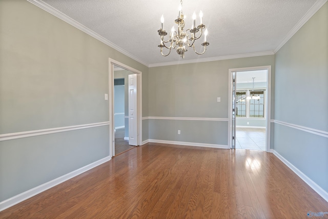 2303 Chatam Ave, Decatur, AL 35603 - unfurnished room with a chandelier, a textured ceiling, wood finished floors, baseboards, and crown molding