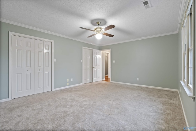 2303 Chatam Ave, Decatur, AL 35603 - unfurnished bedroom with two closets, ornamental molding, carpet, a textured ceiling, and baseboards