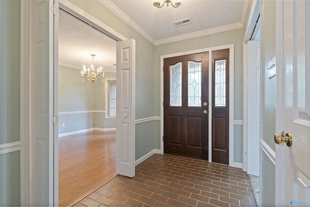 2303 Chatam Ave, Decatur, AL 35603 - foyer with brick patterned floors, a chandelier, a textured ceiling, baseboards, and crown molding