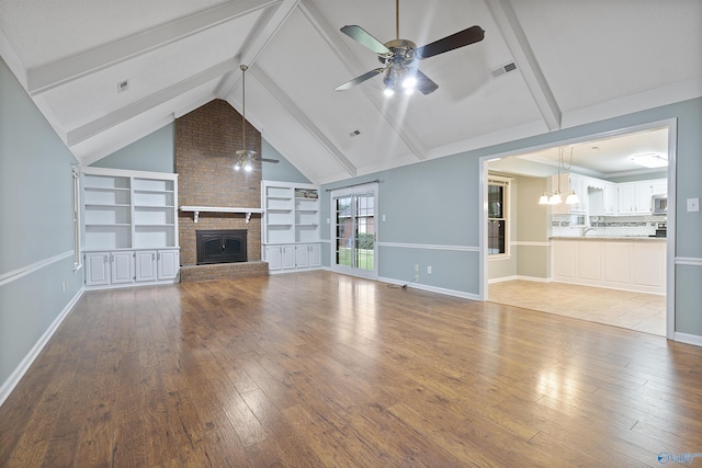 2303 Chatam Ave, Decatur, AL 35603 - unfurnished living room featuring a ceiling fan, hardwood / wood-style flooring, a brick fireplace, and a chandelier