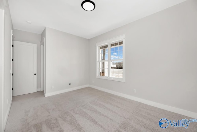 unfurnished room featuring light colored carpet