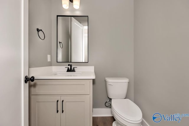 bathroom with vanity, wood-type flooring, and toilet