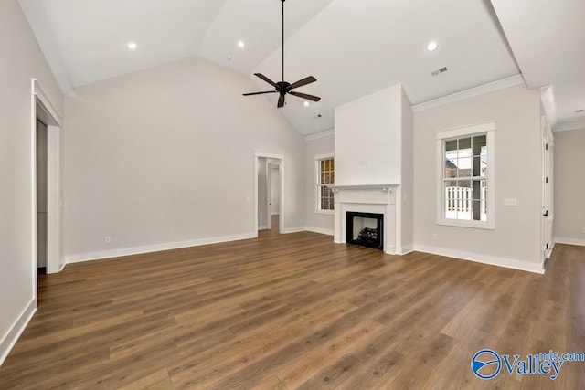 unfurnished living room with dark wood-type flooring, ceiling fan, crown molding, and high vaulted ceiling