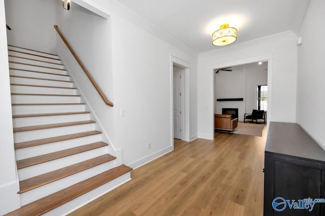 interior space with hardwood / wood-style floors, a large fireplace, and ornamental molding