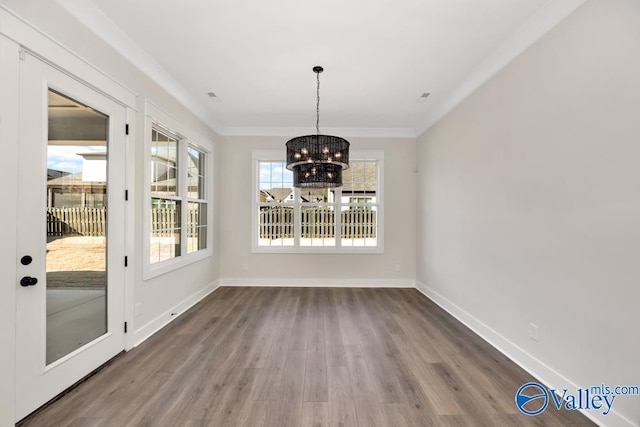 unfurnished dining area featuring a notable chandelier, ornamental molding, and dark hardwood / wood-style floors