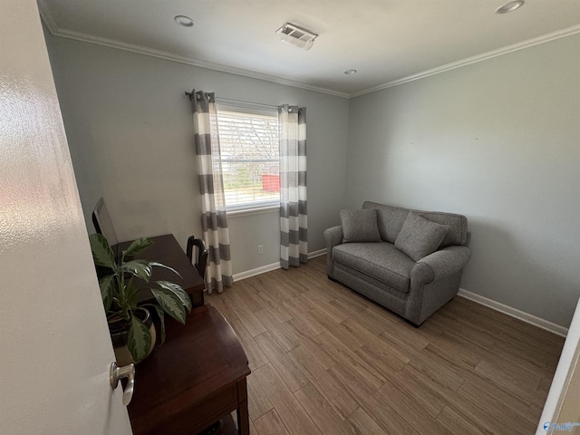 sitting room featuring ornamental molding, baseboards, and wood finished floors