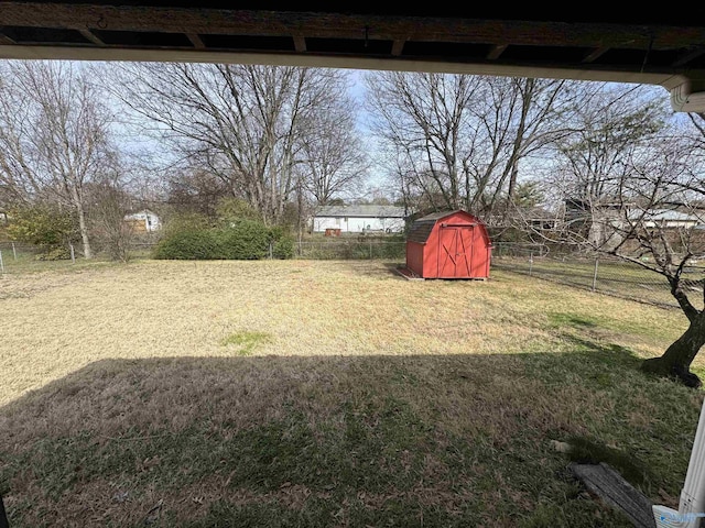 view of yard with a shed, fence, and an outbuilding