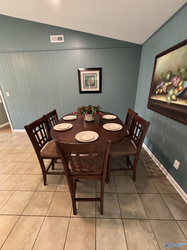 dining room with vaulted ceiling, light tile patterned flooring, visible vents, and baseboards