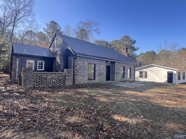 260 County Road 714, Cedar Bluff, AL 35959 - view of front of property featuring a chimney, brick siding, a patio, and a metal roof