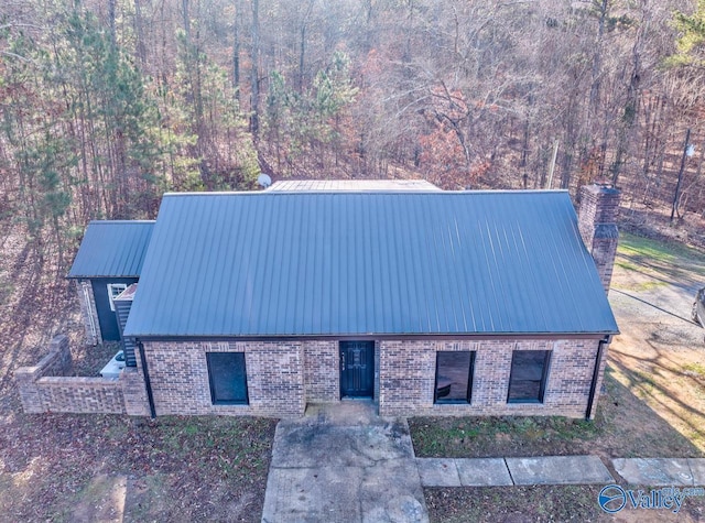 260 County Road 714, Cedar Bluff, AL 35959 - view of front facade featuring brick siding, a metal roof, a forest view, and a chimney