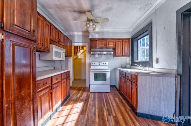 kitchen featuring dark hardwood / wood-style flooring, white appliances, ornamental molding, and sink