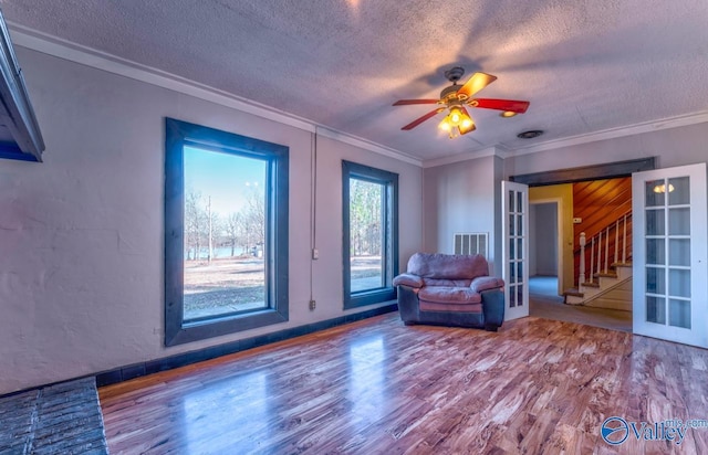 unfurnished room with ornamental molding, wood-type flooring, a textured ceiling, and french doors