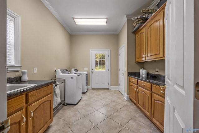 washroom featuring light tile patterned floors, cabinet space, ornamental molding, washing machine and dryer, and baseboards