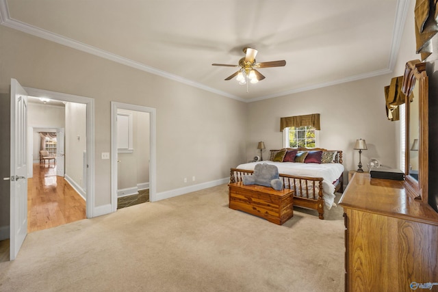 bedroom with a ceiling fan, baseboards, crown molding, and light colored carpet