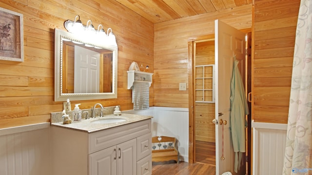 bathroom with hardwood / wood-style flooring, vanity, wooden walls, and wood ceiling