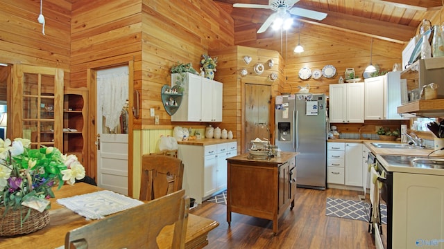 kitchen featuring stainless steel fridge, white cabinetry, sink, and beam ceiling