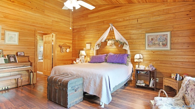 bedroom featuring dark hardwood / wood-style flooring, wood walls, ceiling fan, and vaulted ceiling