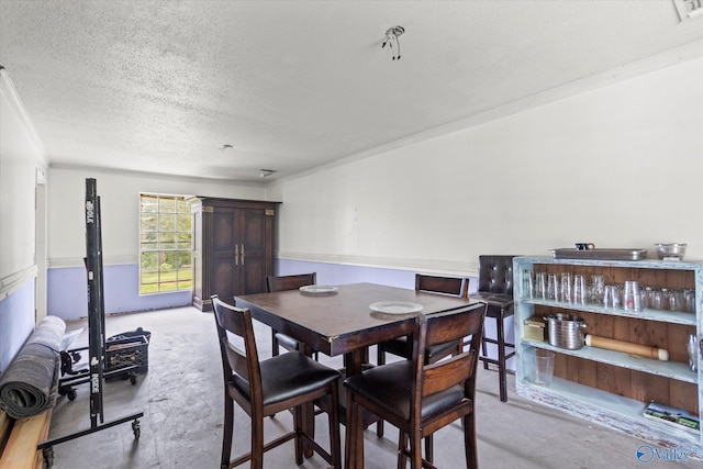 dining space featuring ornamental molding and a textured ceiling