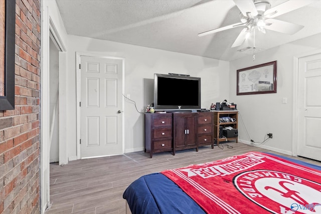 bedroom featuring a textured ceiling, hardwood / wood-style floors, and ceiling fan