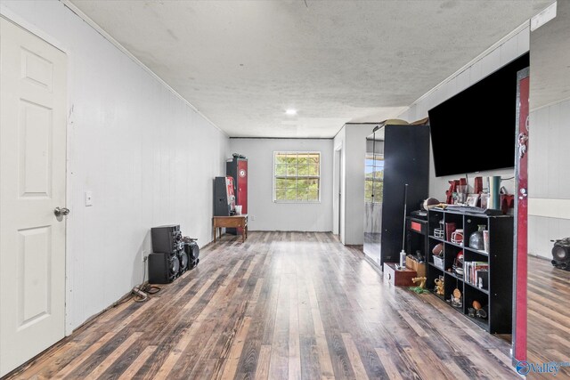 miscellaneous room featuring water heater, a textured ceiling, crown molding, and hardwood / wood-style floors