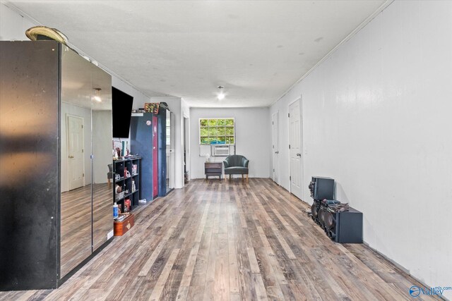 exercise room with cooling unit, ornamental molding, and hardwood / wood-style floors