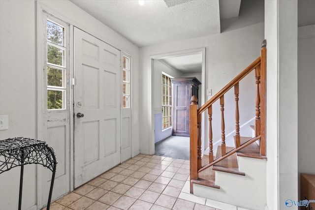 tiled entrance foyer featuring a textured ceiling