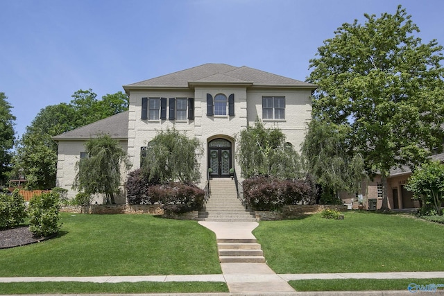 view of front facade featuring french doors, a front lawn, a shingled roof, and brick siding