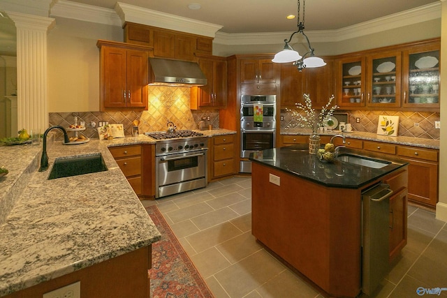 kitchen featuring stainless steel appliances, brown cabinets, a sink, and wall chimney exhaust hood