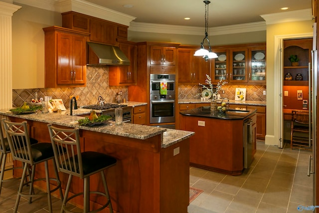 kitchen with stainless steel appliances, wall chimney range hood, kitchen peninsula, light tile patterned floors, and decorative backsplash