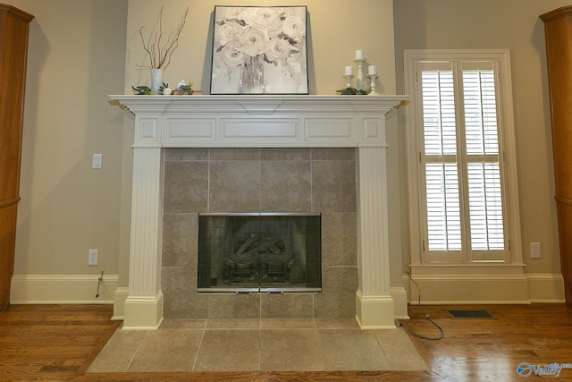 room details with visible vents, decorative columns, baseboards, and wood finished floors